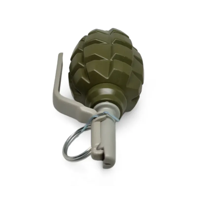 Grenade Pyrosoft PIRO-F1-M couchée, levier gris et anneau de goupille au premier plan