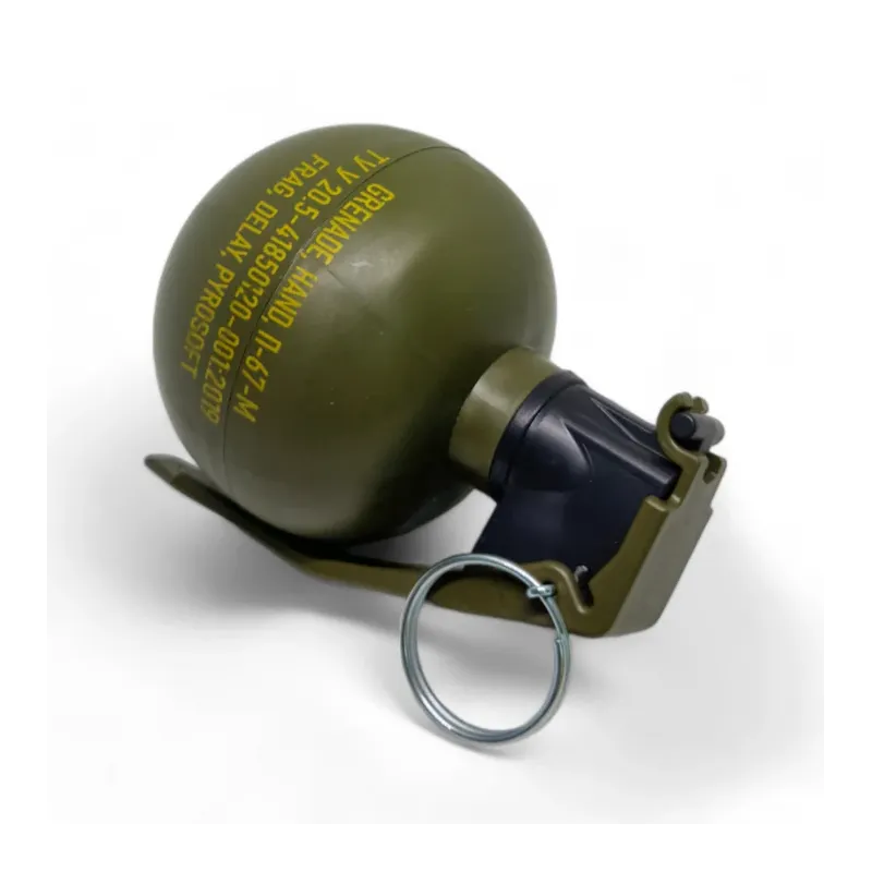 Grenade Pyrosoft P-67-M NATO couchée sur le levier, marquage jaune et anneau visibles