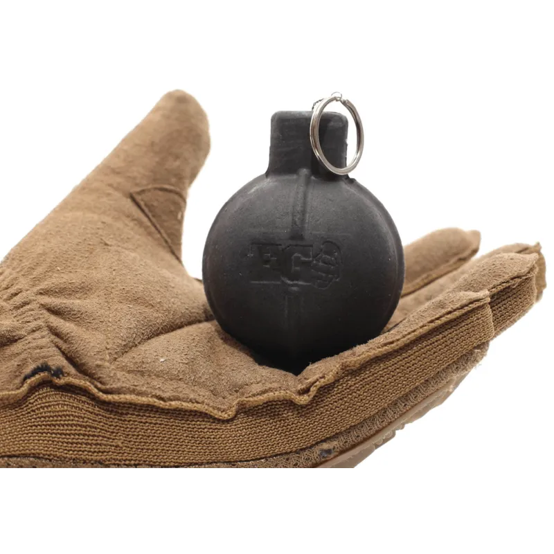 Grenade à billes Enola Gaye EG67 noire tenue dans une main gantée, anneau Wire Pull visible
